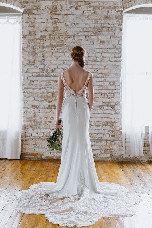 Bride wears crepe and lace Kennedy Blue wedding dress, facing away from the camera