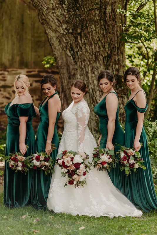 Wedding party wears Kennedy Blue velvet bridesmaid dresses in emerald